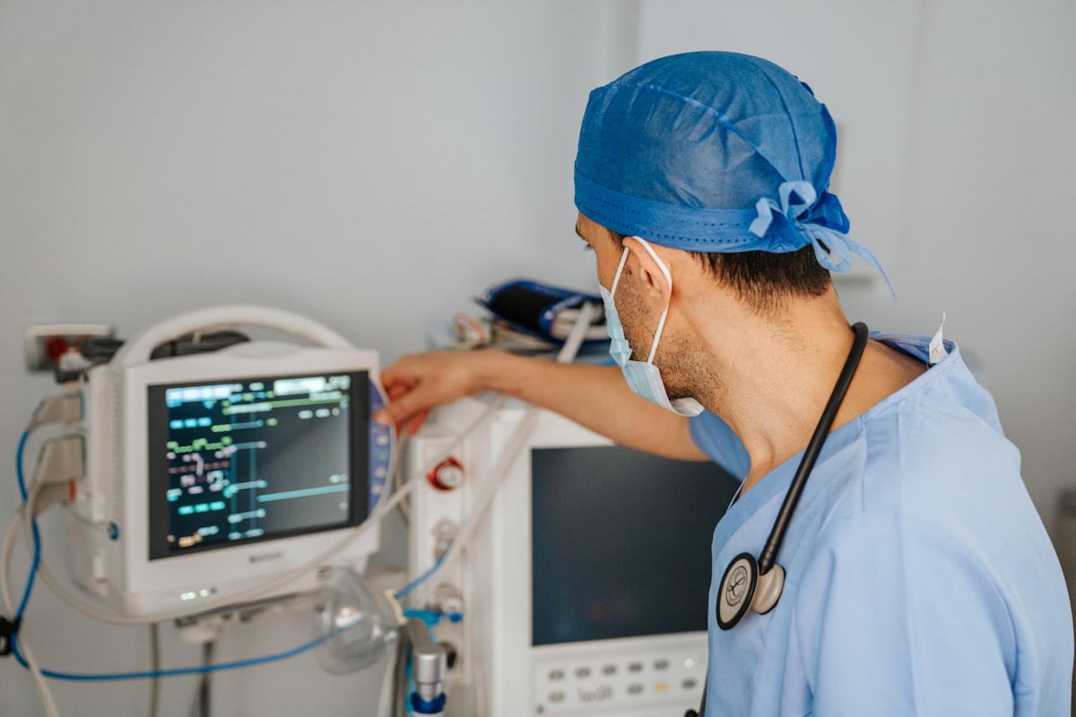 Clinician in scrubs reviewing patient documentation on a monitor